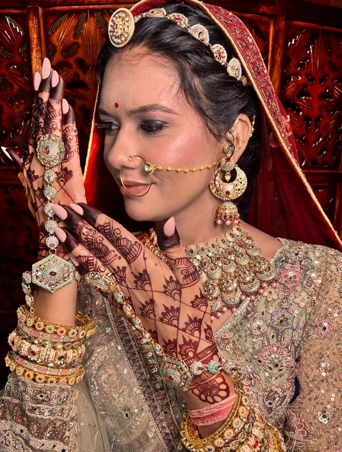 Close-up of a bride in profile with nath, haath phool and intricate mehendi