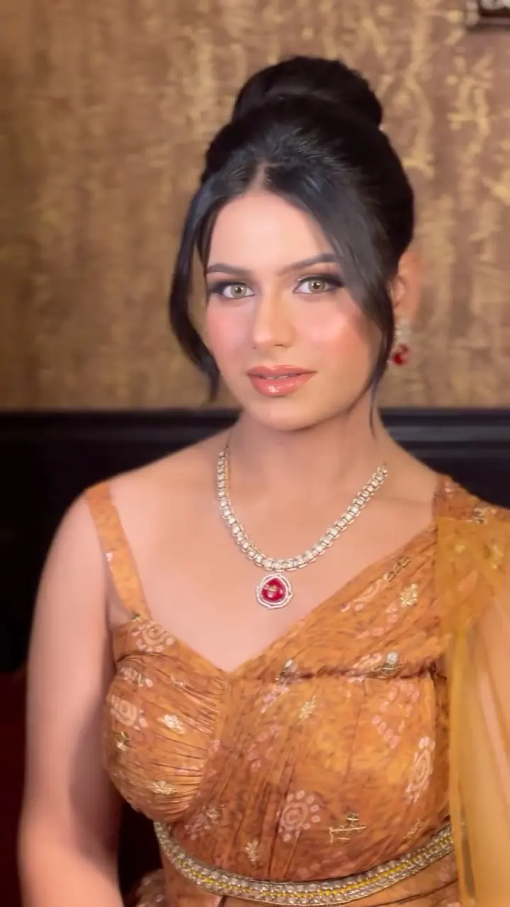Party glam look with a sleek updo, bronzed eyes and a diamond necklace