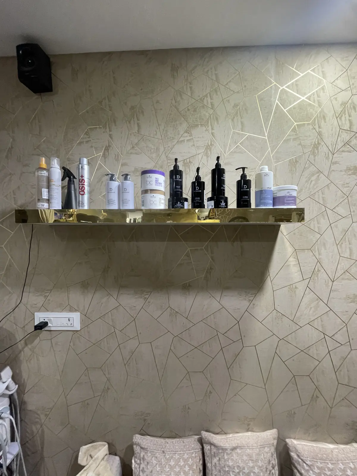 Professional hair-care products on a gold shelf at the salon